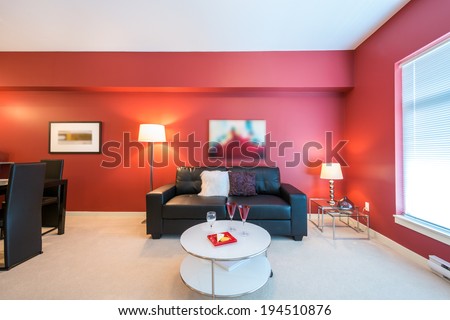 Modern bright, red living room and kitchen with dining room in a luxury house. Interior design.