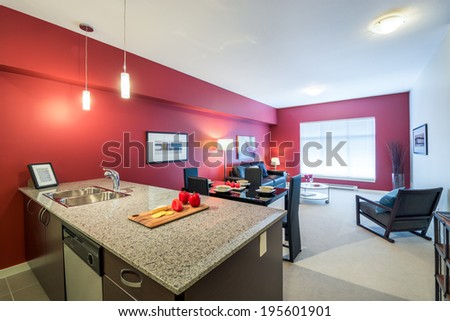 Modern red kitchen with a living room in a luxury apartment. Interior design.
