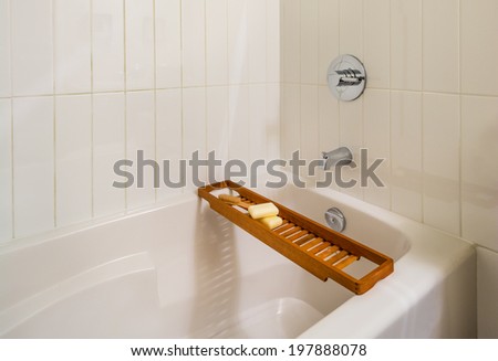 Fragment of luxury bathroom with wood bathroom caddy.