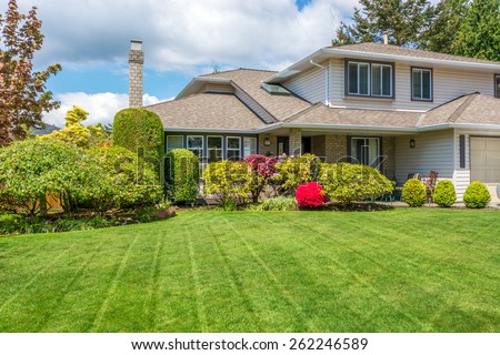 Luxury house with freshly mown grass lawn. Home exterior.