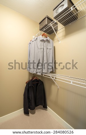Clothes hung neatly in modern wardrobe closet.