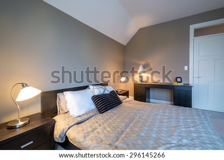 Modern bright bedroom interior design with night tables and office desk.