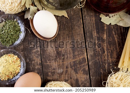 eggs pasta oil and spices on a wooden surface