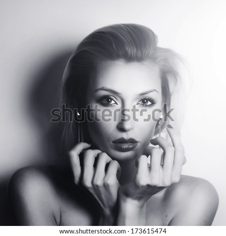 Beautiful elegant blonde woman posing, looking at camera. Sexy lady with evening makeup.
