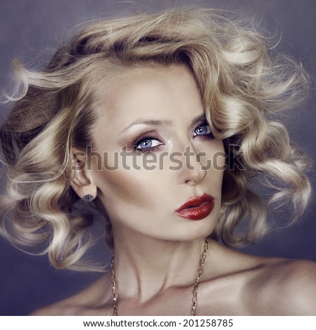 Closeup beauty portrait of young elegant blonde woman with curly hair. Lady looking at camera.