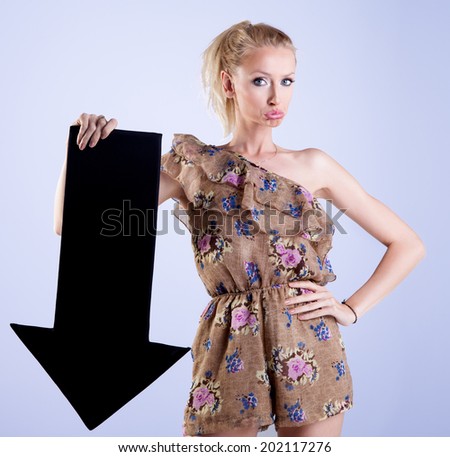 Portrait of beautiful sad blonde woman holding black empty arrow.Studio photo.