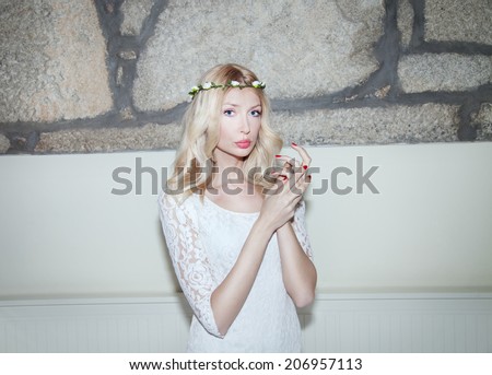 Romantic sensual blonde woman posing, looking at camera. Bride. Girl with curly hair