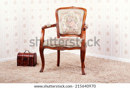 Vintage room with wallpaper and old antique armchair.