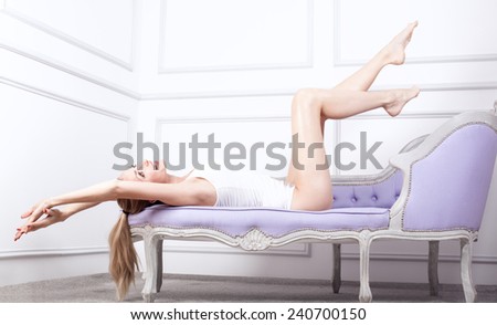 Beautiful smiling blonde woman relaxing, lying. Girl with long slim legs.