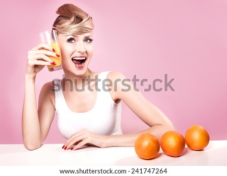 Beautiful young happy woman drinking orange juice, smiling. Healthy lifestyle.
