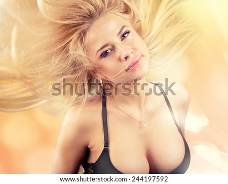 Beauty portrait of blonde young woman in motion. Girl looking at camera.