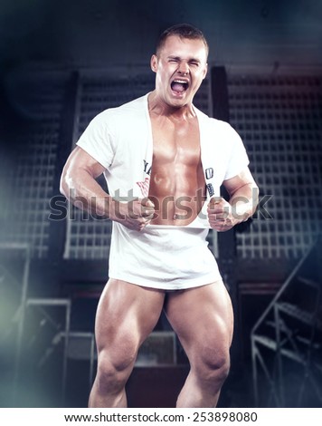 Muscled handsome man posing in studio, emotional male model.