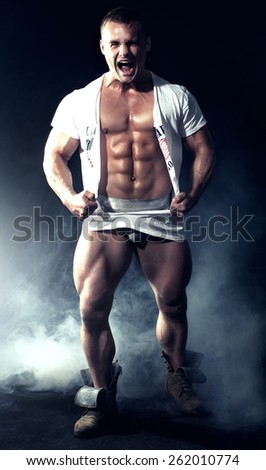 Muscled handsome man posing in studio, emotional male model.