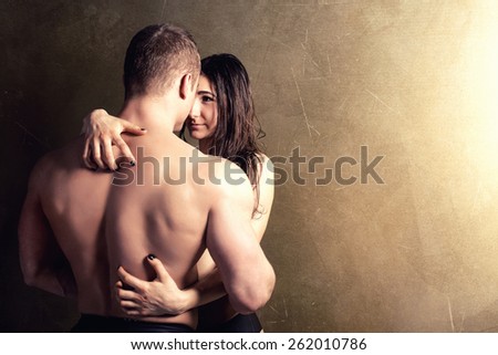 Sexy couple posing in  studio. Handsome muscular man with girlfriend.
