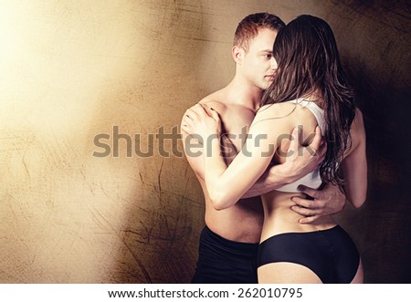 Sexy couple posing in  studio. Handsome muscular man with girlfriend.