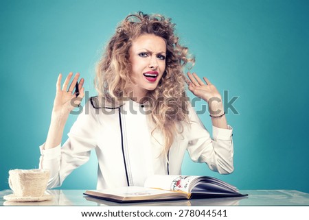 Attractive businesswoman at work. Girl with blonde long curly hair. Blue background.