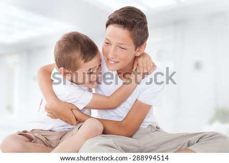 Two brothers posing at home, hugging. Family portrait.