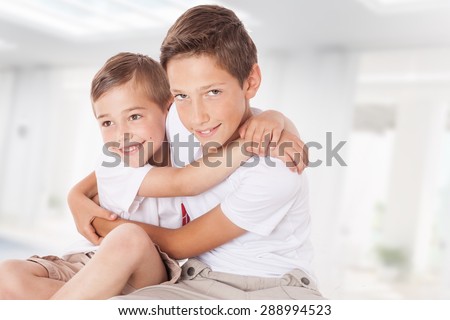 Two brothers posing at home, hugging. Family portrait.