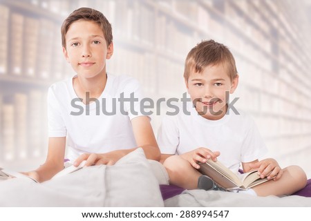 Little brothers reading a books. Family photo.