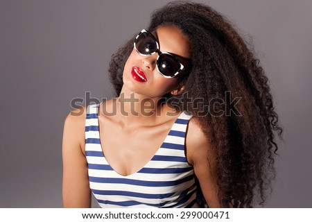 Beautiful stunning portrait of an african american young woman with afro hair. Girl wearing fashionable sunglasses. Studio shot.