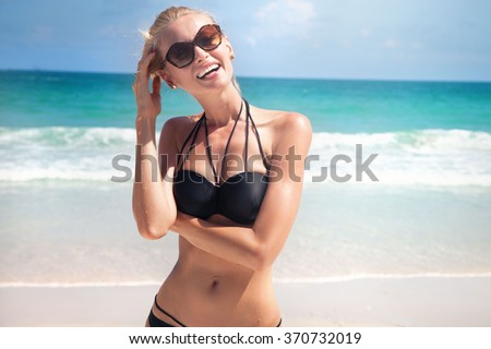 Young beautiful woman spending time on the beach, summer time.