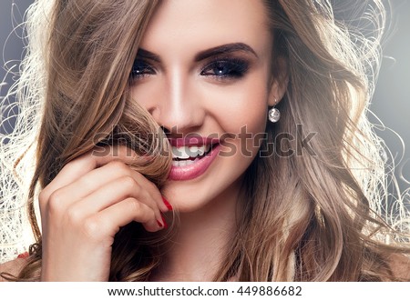 Beauty portrait of elegant young woman. Dark background. Girl looking at camera. Glamour makeup.