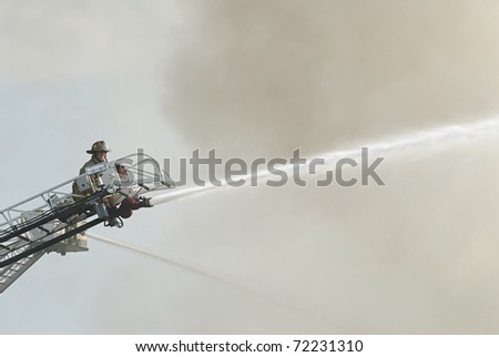 DAYTON, OHIO - AUGUST 15: Fireman on duty battles a warehouse fire from aerial ladder on August 15, 2008 in Dayton, Ohio, USA.