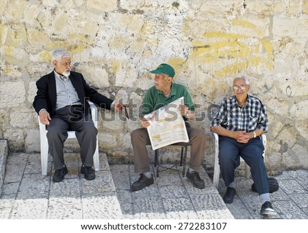 OLD CITY, JERUSALEM-JUNE 9: Three senior men sit on the steps of Casa Nova Road, Christian Quarter, Old City, Jerusalem, relaxing & enjoying a conversation about events in the newspaper, June 9, 2007.