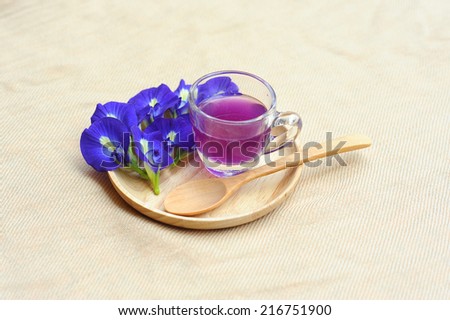 Butterfly Pea and Juice in Glass place Wooden tray on raw cotton background