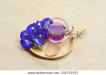 Butterfly Pea and Juice in Glass place Wooden tray on raw cotton background