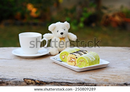 jam rolls in plate and coffee cup on wooden table