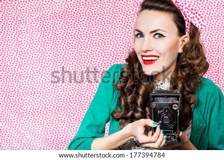 Beautiful happy woman with old camera. studio shot, focus on face