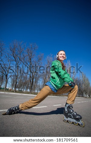 woman skating with rollerblades in a park over blue sky. lower angle shot