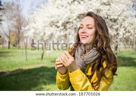 Pretty spring woman with dandelion enjoy the freshness of the new day. focus on face