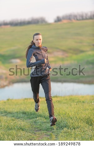 Running woman. Female runner jogging during outdoor workout in countryside in motion