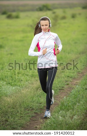 Running woman. Female runner jogging during outdoor workout in motion. Beautiful fit fitness model outdoors
