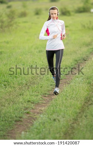 Running woman. Female runner jogging during outdoor workout. Beautiful fit fitness model outdoors