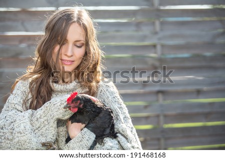 Romantic portrait of young woman holding chicken. Country happy simple life concept. copy space