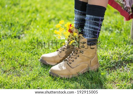 Woman legs in boots over green grass. focus on boot, concept of free happy people