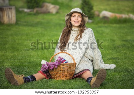 Happy people - free woman enjoying nature sitting on grass happy smiling. soft daylight