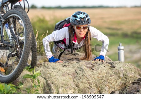 Young athlete working out on a rock with bicycle. Healthy active life. copy space