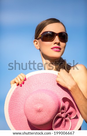 Beautiful woman in hat and sunglasses. Portrait of young attractive girl hide her body with hat