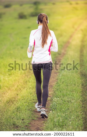 Running woman.  Female fitness model training outside in motion