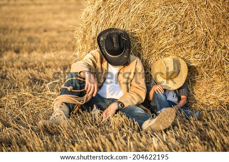 Happy joyful father with a cute son in cowboy hats, family, travel, vacation, father\'s day - concept. focus on father