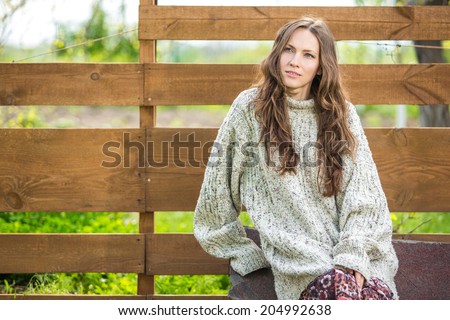 Beautiful autumn sweater woman looking to the side over wooden background