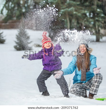 Happy mother and son in winter park having fun. focus on mother