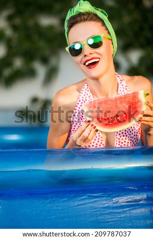 Beauty model with watermelon enjoy her vacation in swimming pool