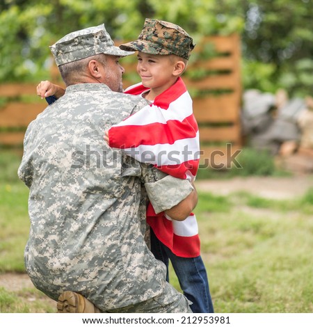 Beautiful modern american family. Father wearing military uniform hugs his son. focus on son