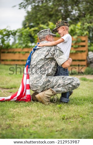 Beautiful modern american family. Father wearing military uniform hugs his son