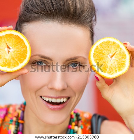 Beauty model girl with juicy oranges. Beautiful joyful fashion girl with funky hairstyle and natural makeup. focus on eyes